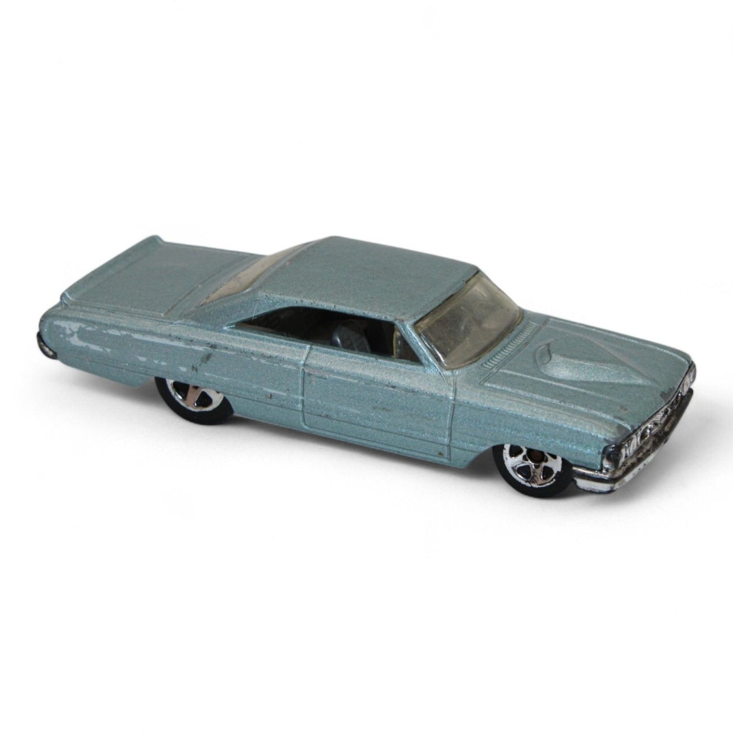 Vintage diecast model of a blue Chevy Impala, featuring chrome accents, black interior, and classic 1960s styling with minor play wear.