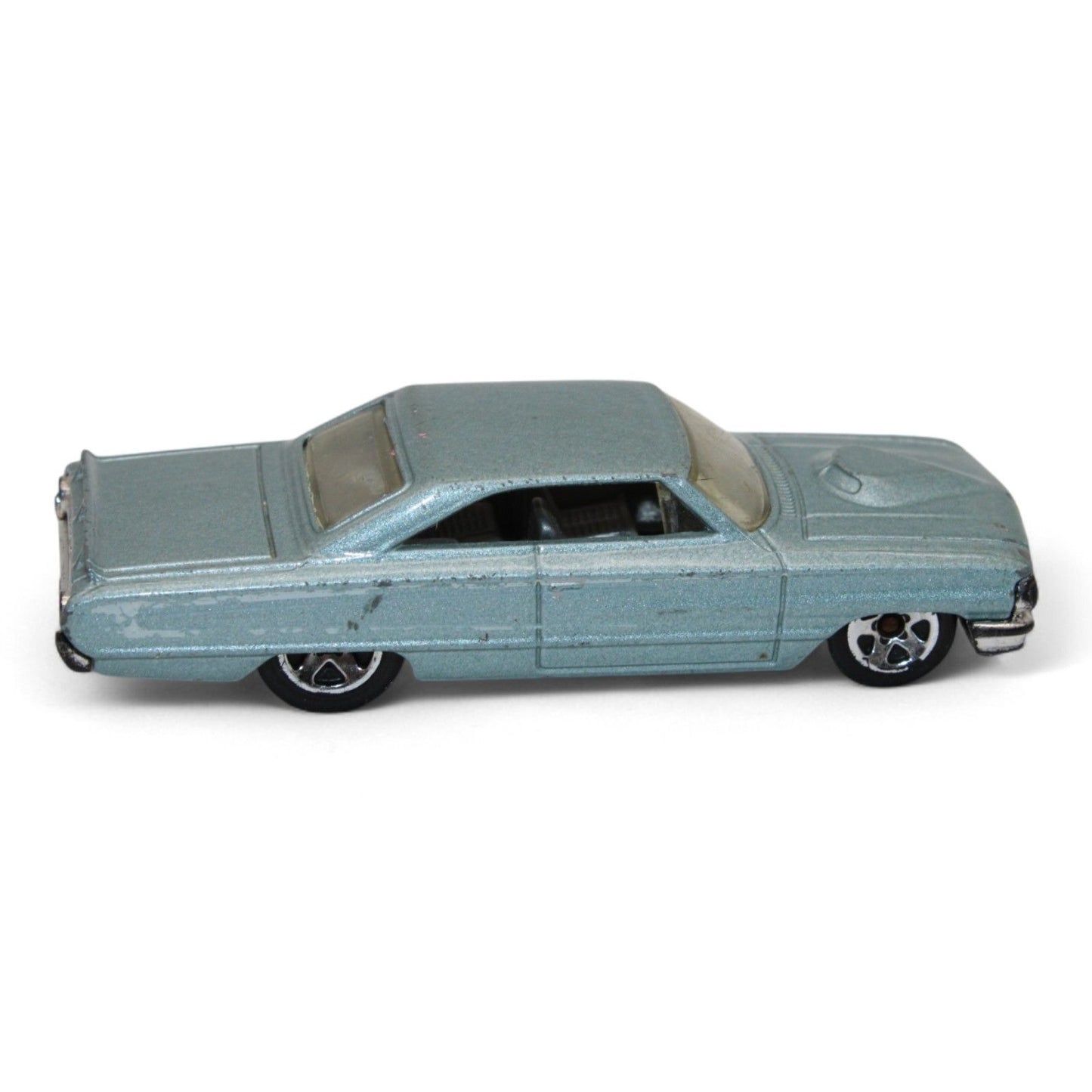 Vintage diecast model of a blue Chevy Impala, featuring chrome accents, black interior, and classic 1960s styling with minor play wear.