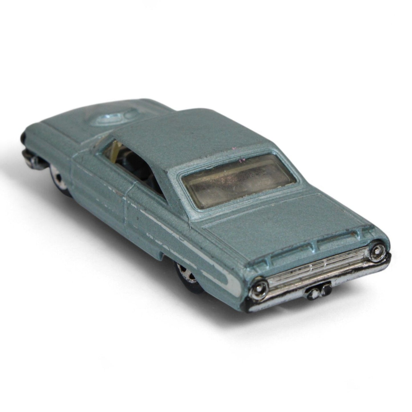 Vintage diecast model of a blue Chevy Impala, featuring chrome accents, black interior, and classic 1960s styling with minor play wear.