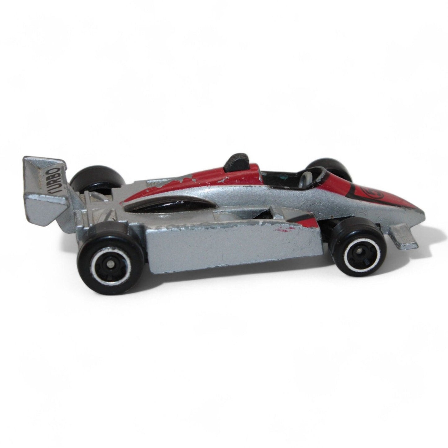 A silver and red diecast formula‑style race car toy with number 5 livery, vintage 1:64 scale metal model in fair play condition.