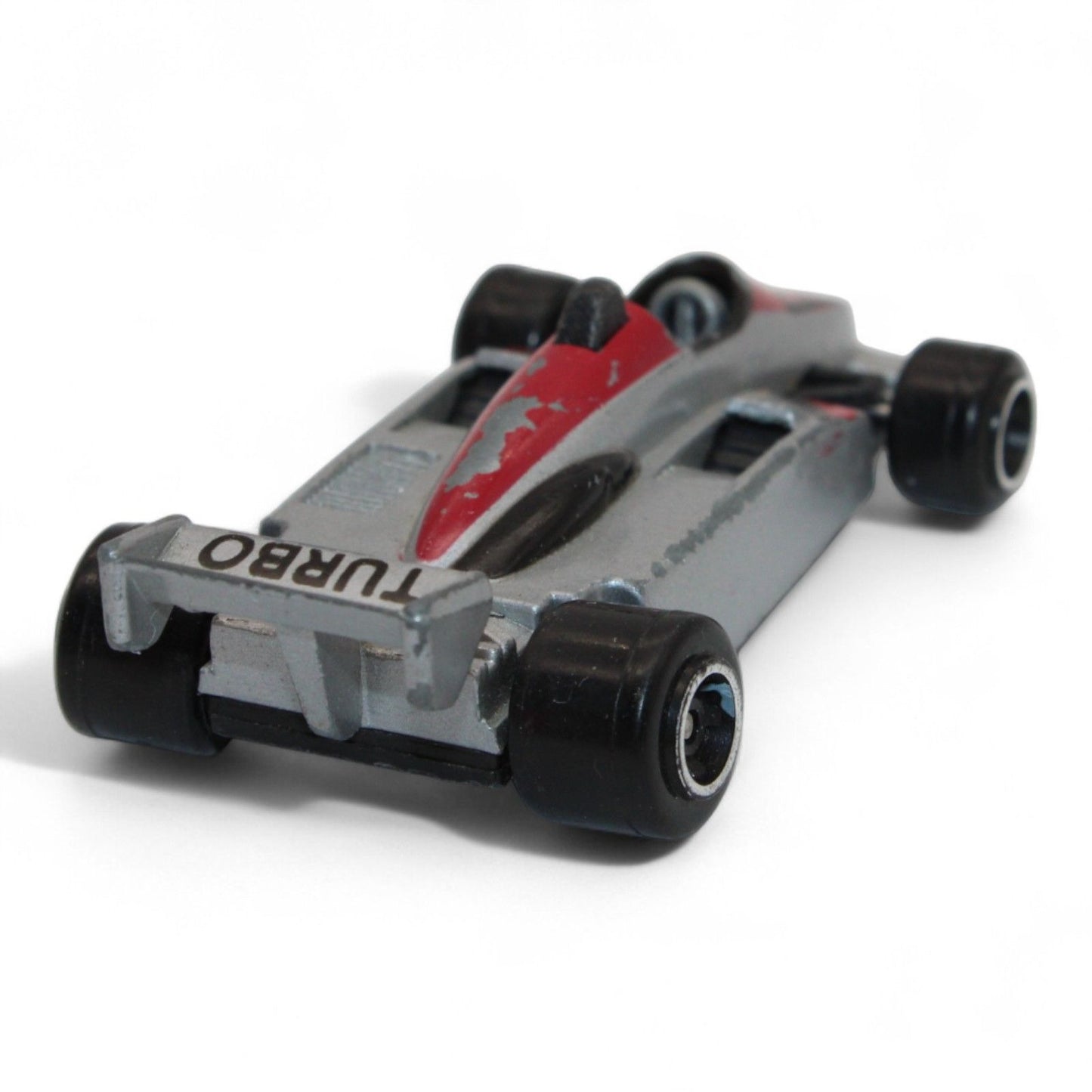 A silver and red diecast formula‑style race car toy with number 5 livery, vintage 1:64 scale metal model in fair play condition.