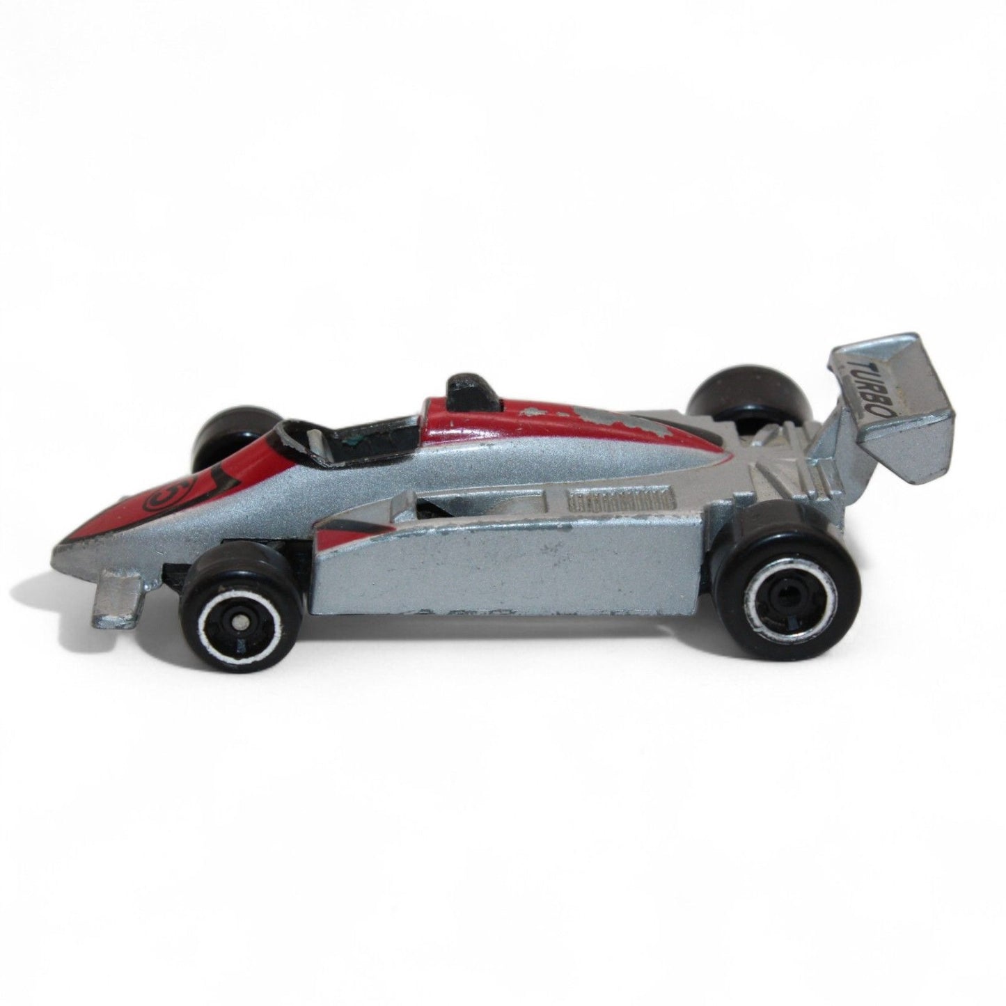 A silver and red diecast formula‑style race car toy with number 5 livery, vintage 1:64 scale metal model in fair play condition.