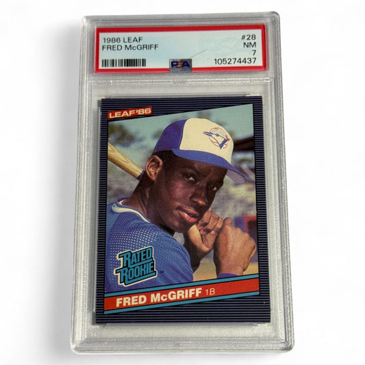 A PSA 7 near‑mint 1986 Leaf Fred McGriff rookie card #28 featuring the future Hall of Famer in a Rated Rookie Blue Jays uniform, classic early pose.
