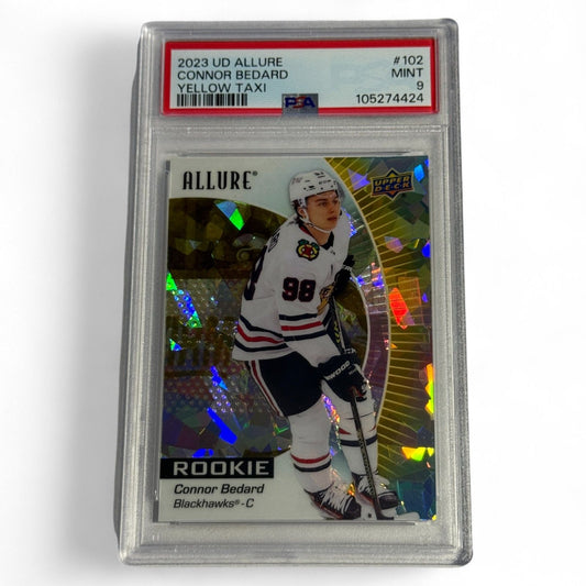 A PSA 9 mint 2023 Upper Deck Allure #102 Yellow Taxi parallel rookie card of Connor Bedard in his Chicago Blackhawks uniform, premium foil finish.
