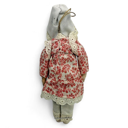Back view of a porcelain doll wearing a red floral dress with lace trim