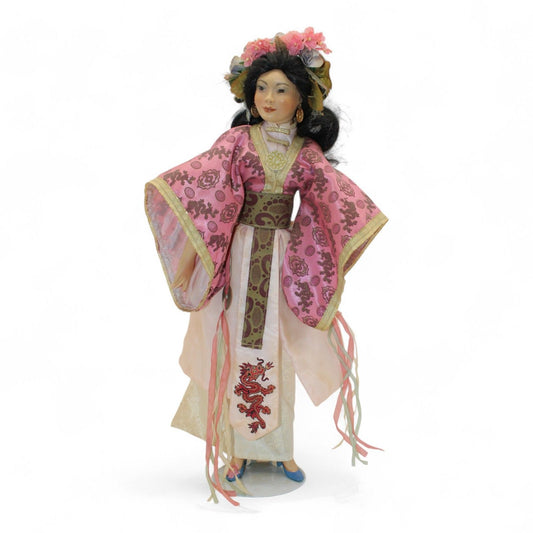 Elegant Asian princess doll dressed in ornate pink and gold robes with dragon embroidery, wearing floral headdress and jewelry accents.
