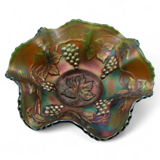 A vintage Fenton Carnival Glass ruffled bowl in grape vine pattern with iridescent amethyst tones, perfect as a decorative candy or centerpiece dish.
