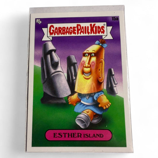 2023 Topps Chrome Garbage Pail Kids card #15a features Esther Island, a girl with a Moai statue head walking among Easter Island heads.  
