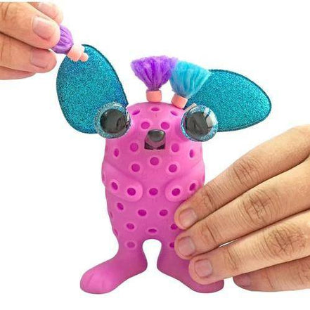 Hands assembling KaPoof Pets Lopsy toy with accessories