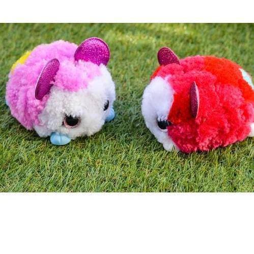 Two plush toys on grass, one red and one pink