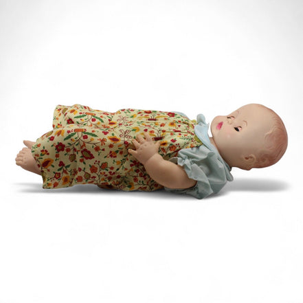 Side view of Madame Alexander doll lying down in floral outfit