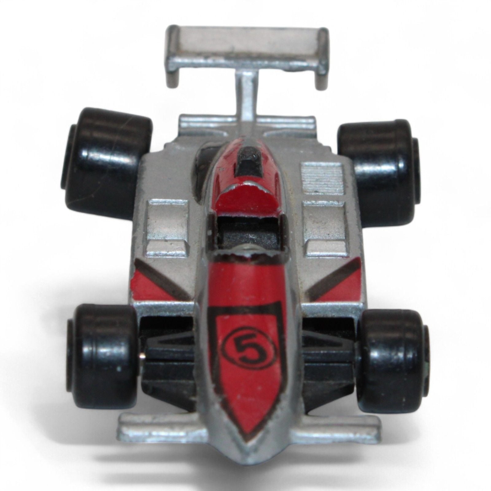 A silver and red diecast formula‑style race car toy with number 5 livery, vintage 1:64 scale metal model in fair play condition.
