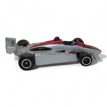 A silver and red diecast formula‑style race car toy with number 5 livery, vintage 1:64 scale metal model in fair play condition.
