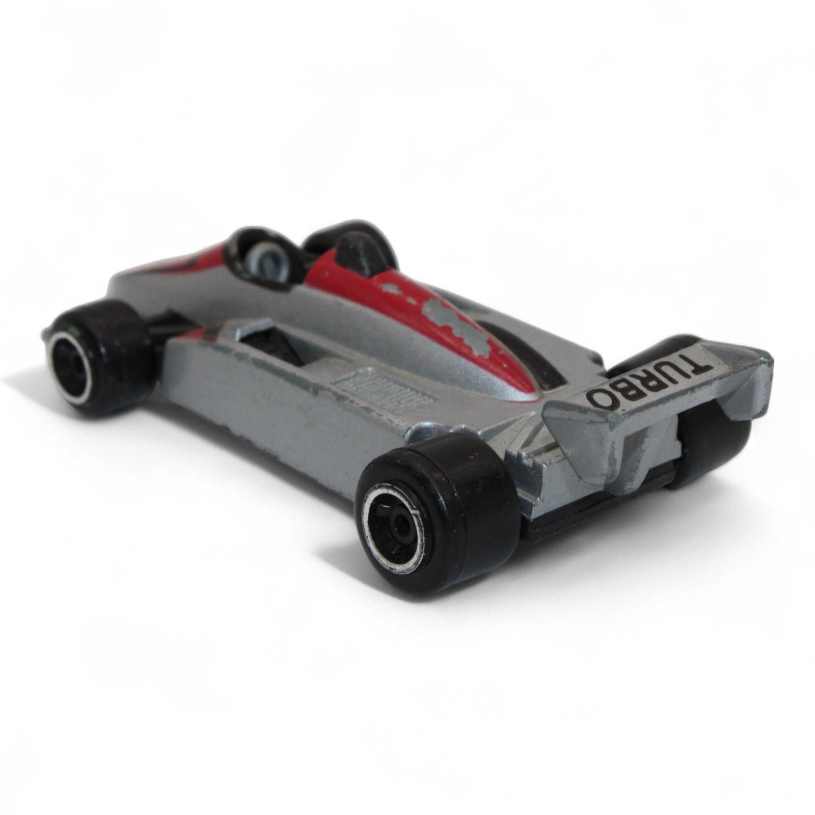 A silver and red diecast formula‑style race car toy with number 5 livery, vintage 1:64 scale metal model in fair play condition.
