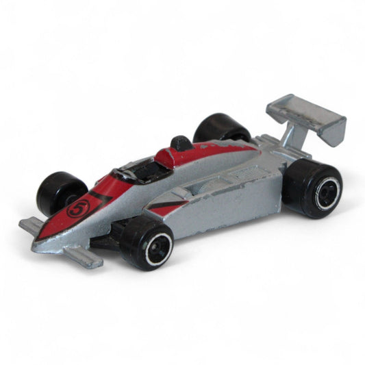 A silver and red diecast formula‑style race car toy with number 5 livery, vintage 1:64 scale metal model in fair play condition.
