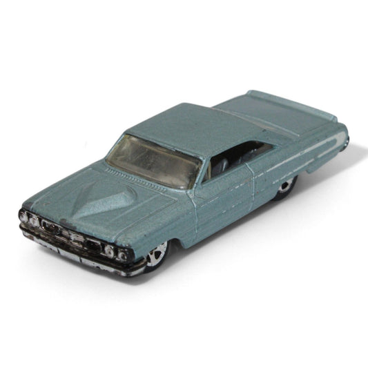 Vintage diecast model of a blue Chevy Impala, featuring chrome accents, black interior, and classic 1960s styling with minor play wear.
