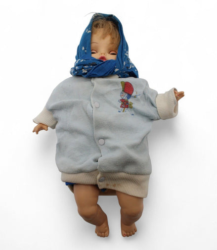 Vintage baby doll wearing a blue scarf and light blue outfit