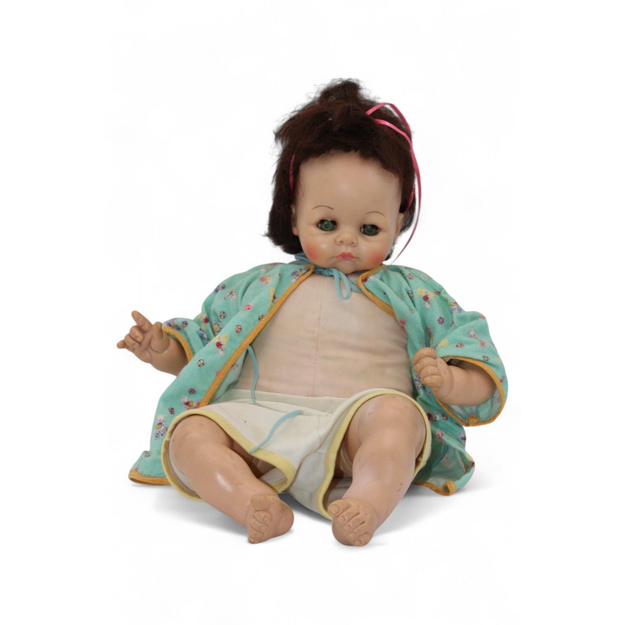 Close-up of the vintage doll's face showing glass eyes and brown hair.