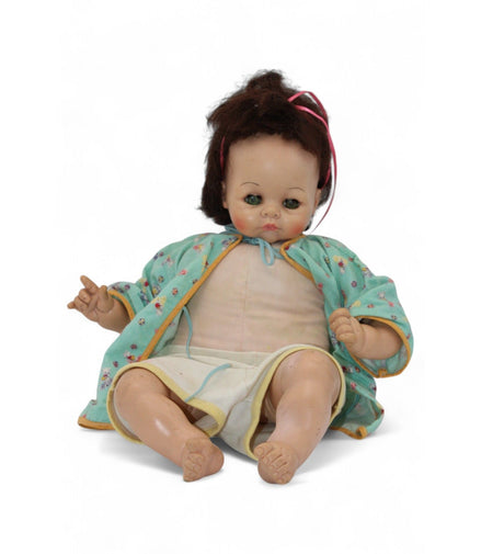 Close-up of the vintage doll's face showing glass eyes and brown hair.