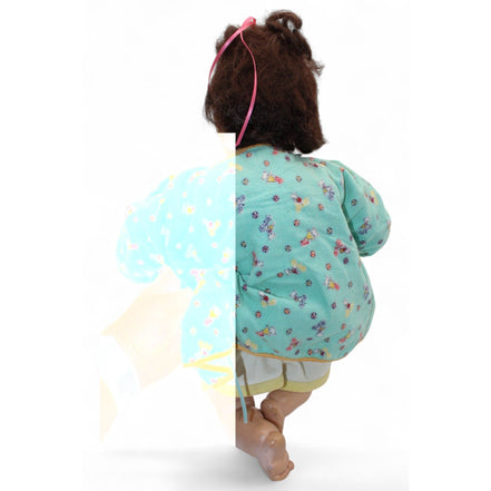 Back view of the vintage doll's green floral jacket.