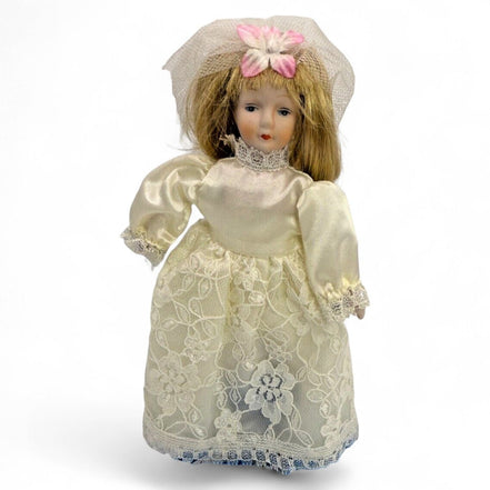 Vintage porcelain bride doll with lace dress and veil, front view