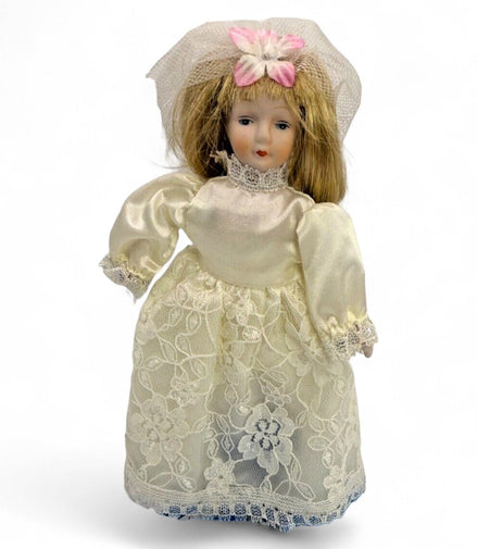 Vintage porcelain bride doll with lace dress and veil, front view