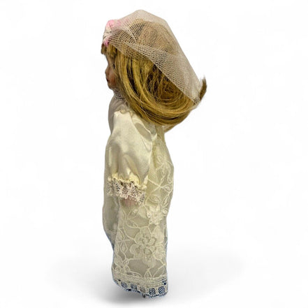 Side view of vintage porcelain bride doll with lace dress and veil