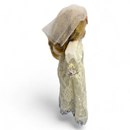 Detailed view of vintage porcelain bride doll's lace dress and veil