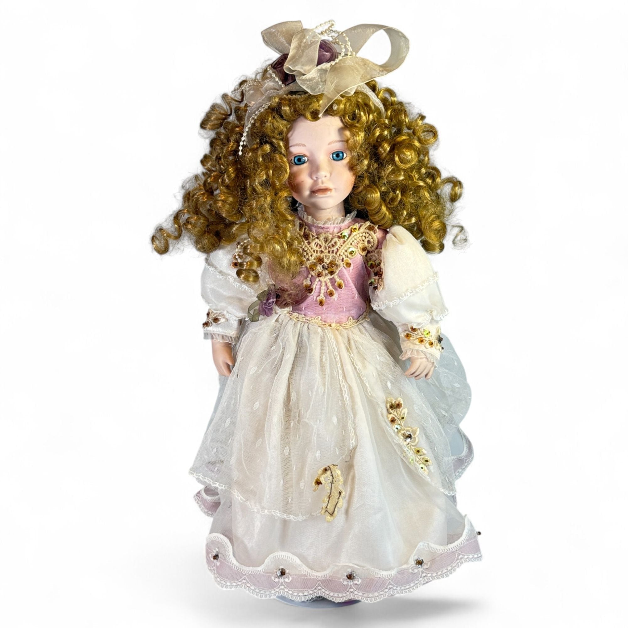 Vintage porcelain doll with blonde curly hair and Victorian dress