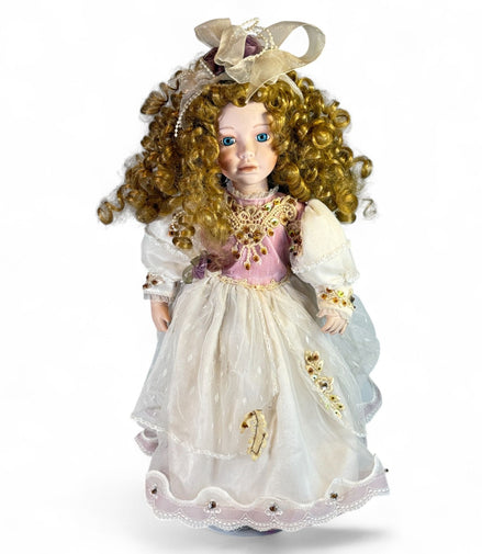 Vintage porcelain doll with blonde curly hair and Victorian dress