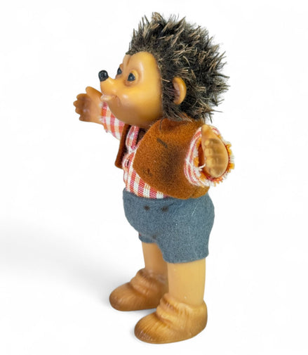 Side view of vintage Steiff hedgehog toy in plaid shirt