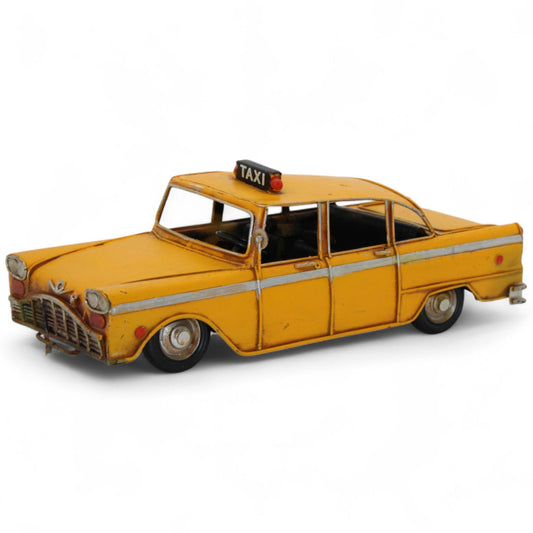 Angled front view of vintage yellow taxi die-cast model with realistic wear and roof light sign.  
