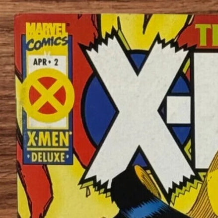 Close-up of the Marvel Comics logo and X-Men Deluxe label on the comic cover.